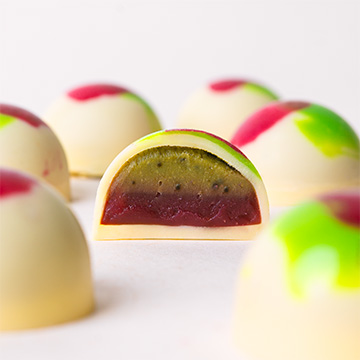 pralina o smaku matchy i malin z białej belgijskiej czekolady