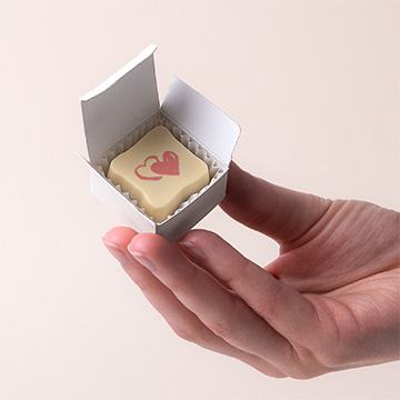 Prezentowana w dłoni pralinka z personalizowaną grafiką dla gości