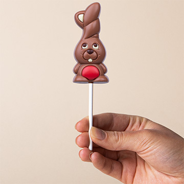 czerwony zajączek czekoladowy na Wielkanoc prezentowany w dłoni