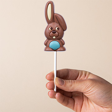 niebieski zajączek czekoladowy na Wielkanoc prezentowany w dłoni