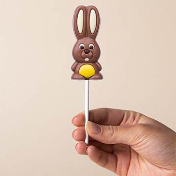 ż&oacute;łty zajączek czekoladowy na Wielkanoc prezentowany w dłoni