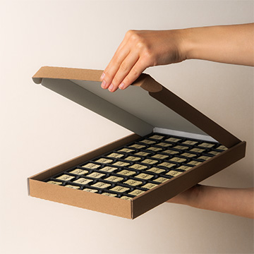 zestaw 50 pralin personalizowanych logotypem twojej firmy prezentowany w dłoniach