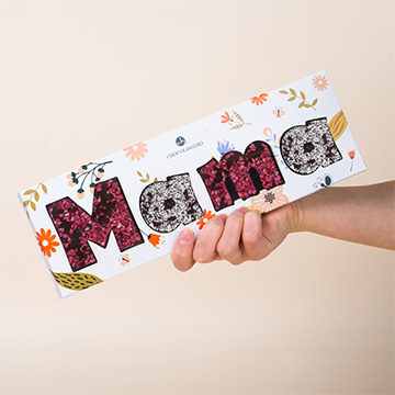 Czekoladowy napis Mama wykonany z belgijskiej czekolady gorzkiej prezentowanej w dloniach