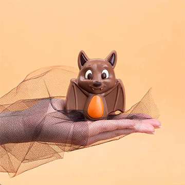 nietoperz z belgijskiej czekolady na halloween prezentowany na dłoni