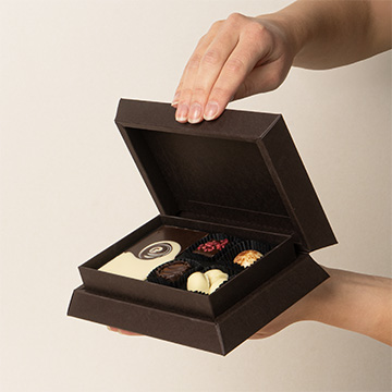 zestaw czekoladowych słodkości w belgijskiej czekoladzie prezentowany w dłoniach