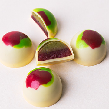 praliny z białej belgijskiej czekolady wykonane ręcznie z nadzieniem o smaku matchy i malin